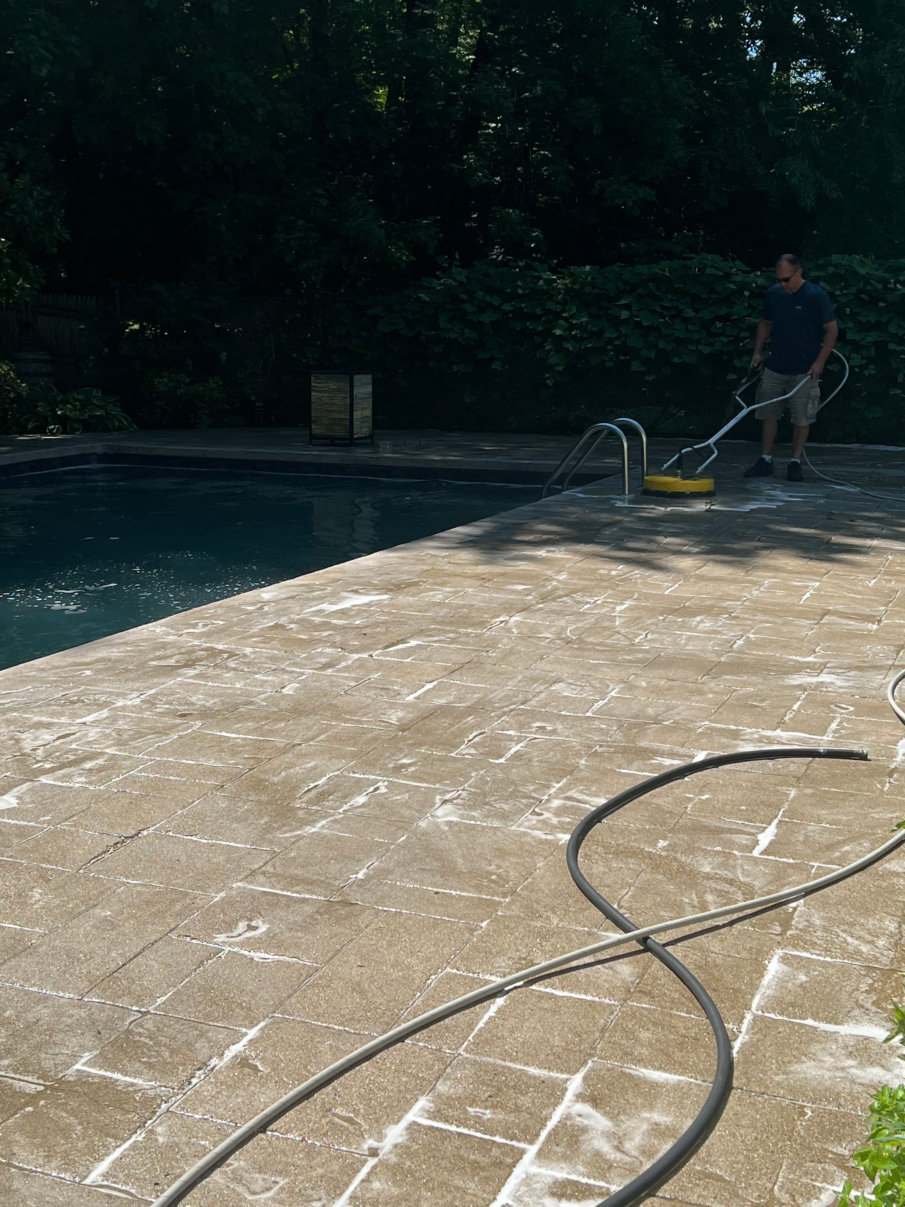 Graham Power Washing crew pressure washing a paver pool deck and hard surface